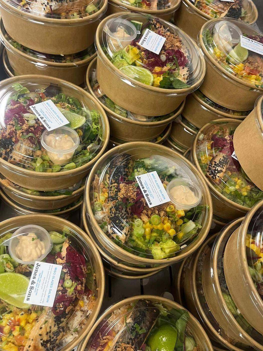 Labelled individual salad bowls with dressing pots, stacked for delivery